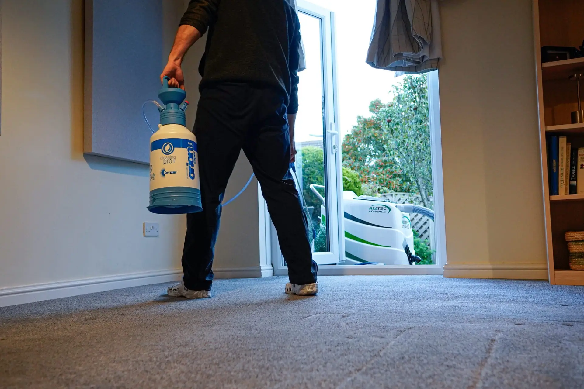 Spraying cleaning solution onto a carpet before brushing it in
